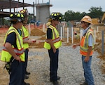 Stephen Surridge, a safety representative with Hensel Phelps Construction, right, for the Defense Logistics Agency Aviation Operations Center provides DLA Installation Support at Richmond Virginia, Firefighters Ryan Council, left front, Captain Kevin Pickeral, left rear, and Firefighter Jamie MacFarlane, center, a tour and safety briefing about the new center construction. The tour was part of Safety Stand Down Week June 19-25, 2016 and informs the fire department about what is going on at the site and how the building is built. 