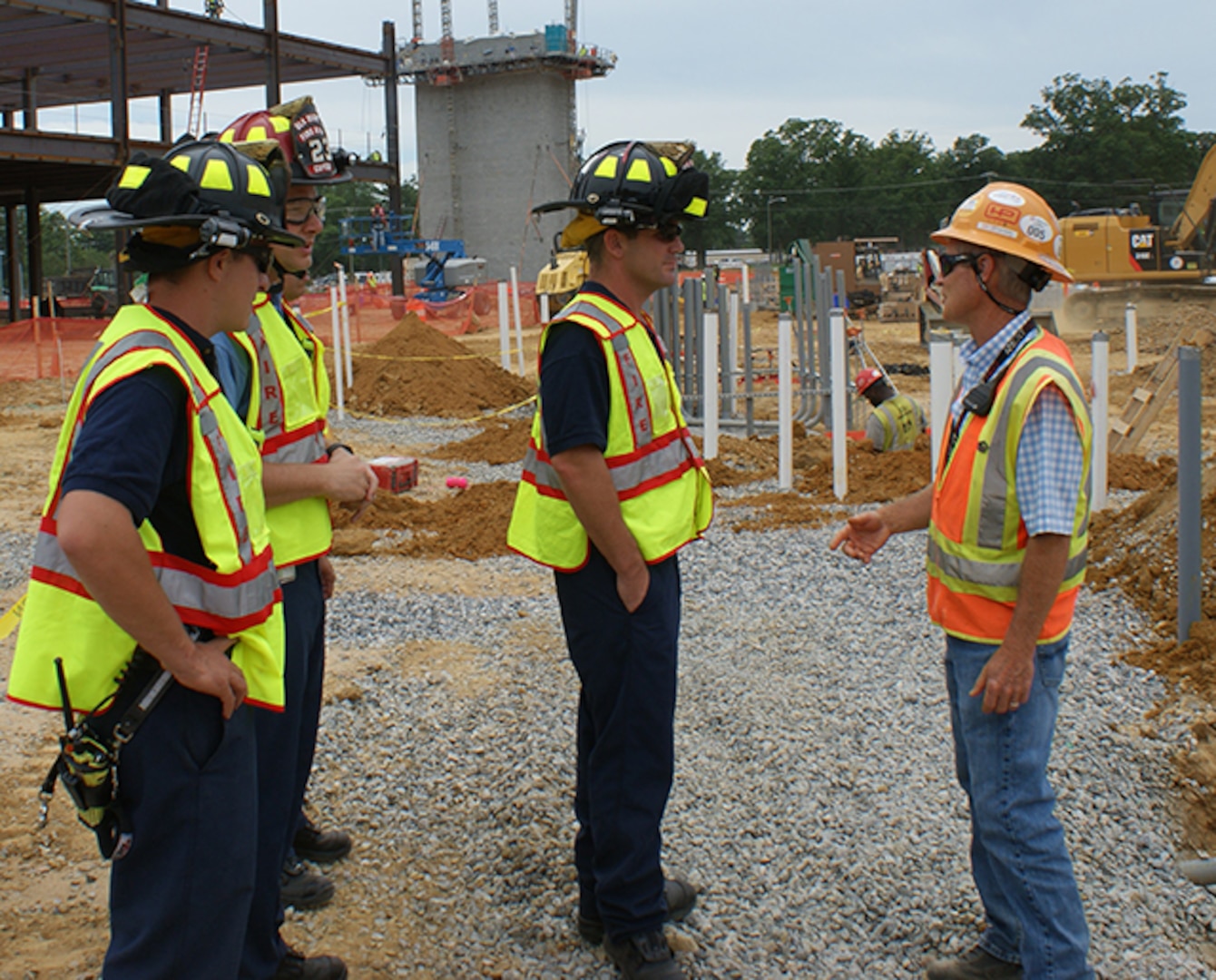 Stephen Surridge, a safety representative with Hensel Phelps Construction, right, for the Defense Logistics Agency Aviation Operations Center provides DLA Installation Support at Richmond Virginia, Firefighters Ryan Council, left front, Captain Kevin Pickeral, left rear, and Firefighter Jamie MacFarlane, center, a tour and safety briefing about the new center construction. The tour was part of Safety Stand Down Week June 19-25, 2016 and informs the fire department about what is going on at the site and how the building is built. 