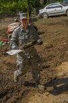 Air Force Capt. Lori Wyatt of the 167th Airlift Wing, Martinsburg, W.Va., picks up debris on June 26, in Clendenin, W.Va. The June 23, 2016, flood caused widespread damage throughout the state leading W.Va. Gov. Earl Ray Tomblin to declare a State of Emergency in 44 of the 55 counties.