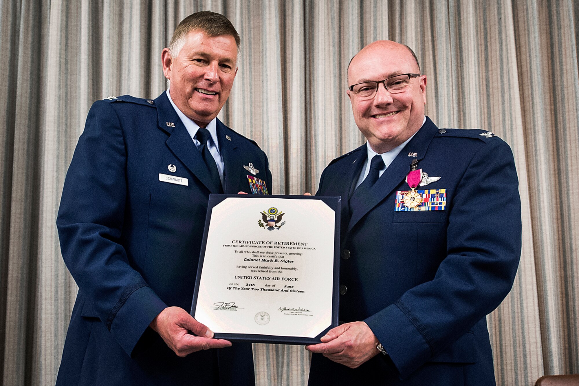 Col. (Ret.) Doug Schwartz, former 434th Air Refueling Wing commander, left, presents Col. Mark Sigler, 434th Operations Group commander his certificate of retirement during a ceremony June 22, 2016 at Grissom Air Reserve Base. Sigler retired with more than 30 years of military Service. (U.S. Air Force photo/Douglas Hays)