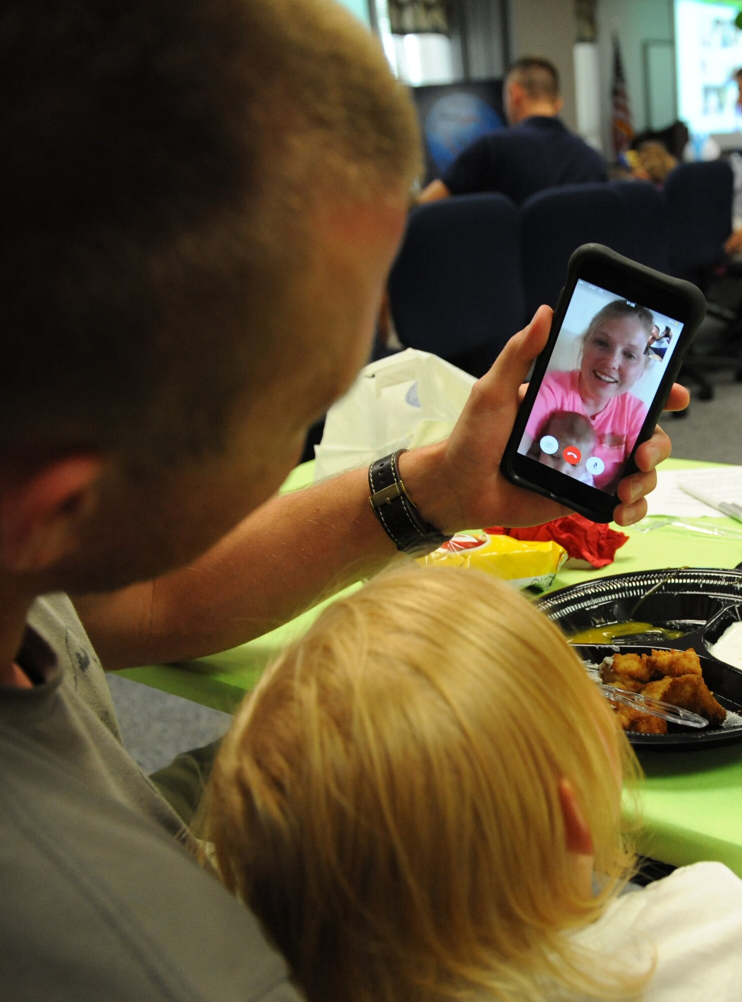 Second Lt. Ryan Kirklin, 333rd Training Squadron undergraduate cyber student, and his daughter, Reese, face time with his wife, Brittany, during a Daddy/Daughter Dinner and a “Do” event at the Sablich Center June 24, 2016 on Keesler Air Force Base, Miss. The event included dinner and hands-on hair styling techniques for the dads, which provided a valuable opportunity for sharing, learning new practical skills and deepening the bond between the dads and their daughters. (U.S. Air Force photo by Kemberly Groue/Released)