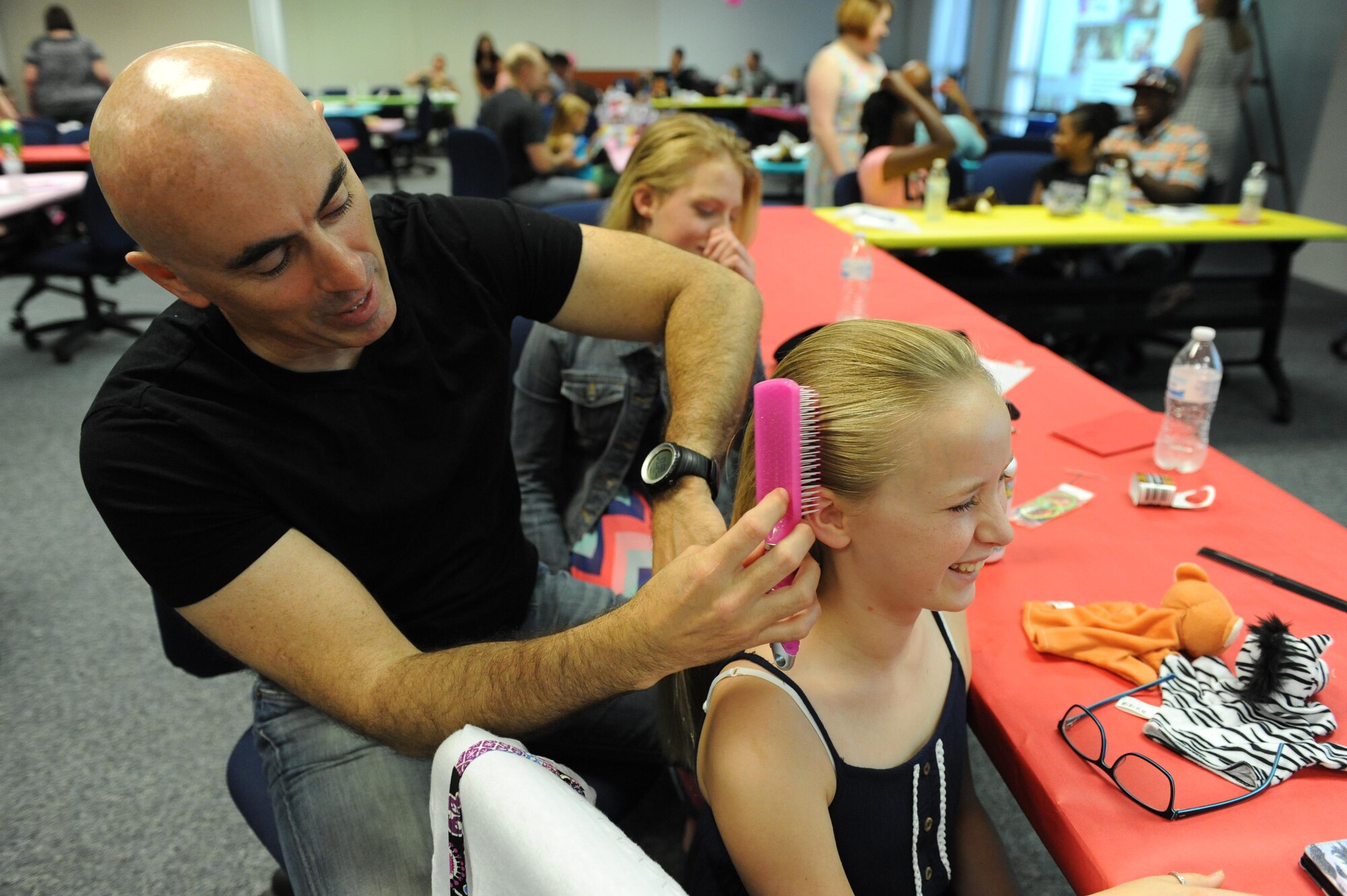 Retired Maj. Lamar Settlemires, brushes his daughter Elena’s hair during a Daddy/Daughter Dinner and a “Do” event at the Sablich Center June 24, 2016 on Keesler Air Force Base, Miss. The event included dinner and hands-on hair styling techniques for the dads, which provided a valuable opportunity for sharing, learning new practical skills and deepening the bond between the dads and their daughters. (U.S. Air Force photo by Kemberly Groue/Released)