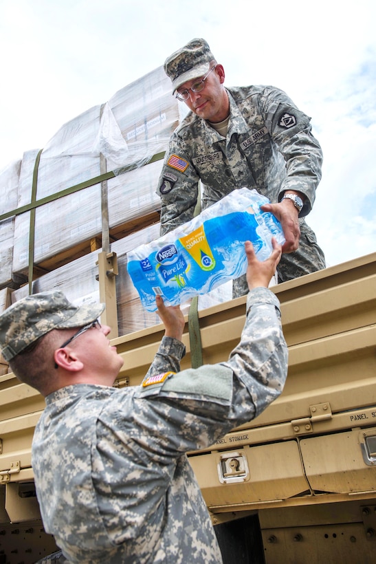 Army Sgt. Brian Loudenburg, right, and Spc. Thomas Ochoa load water onto a truck at the Joint Base West Virginia National Guard Alternate Supply Location Operations facility in Dunbar, W.Va., June 27, 2016, for delivery to state residents affected by flooding. Loudenburg and Ochoa are assigned to the West Virginia Air National Guard’s the 1257th Transportation Company. Air National Guard photo by Tech. Sgt. De-Juan Haley