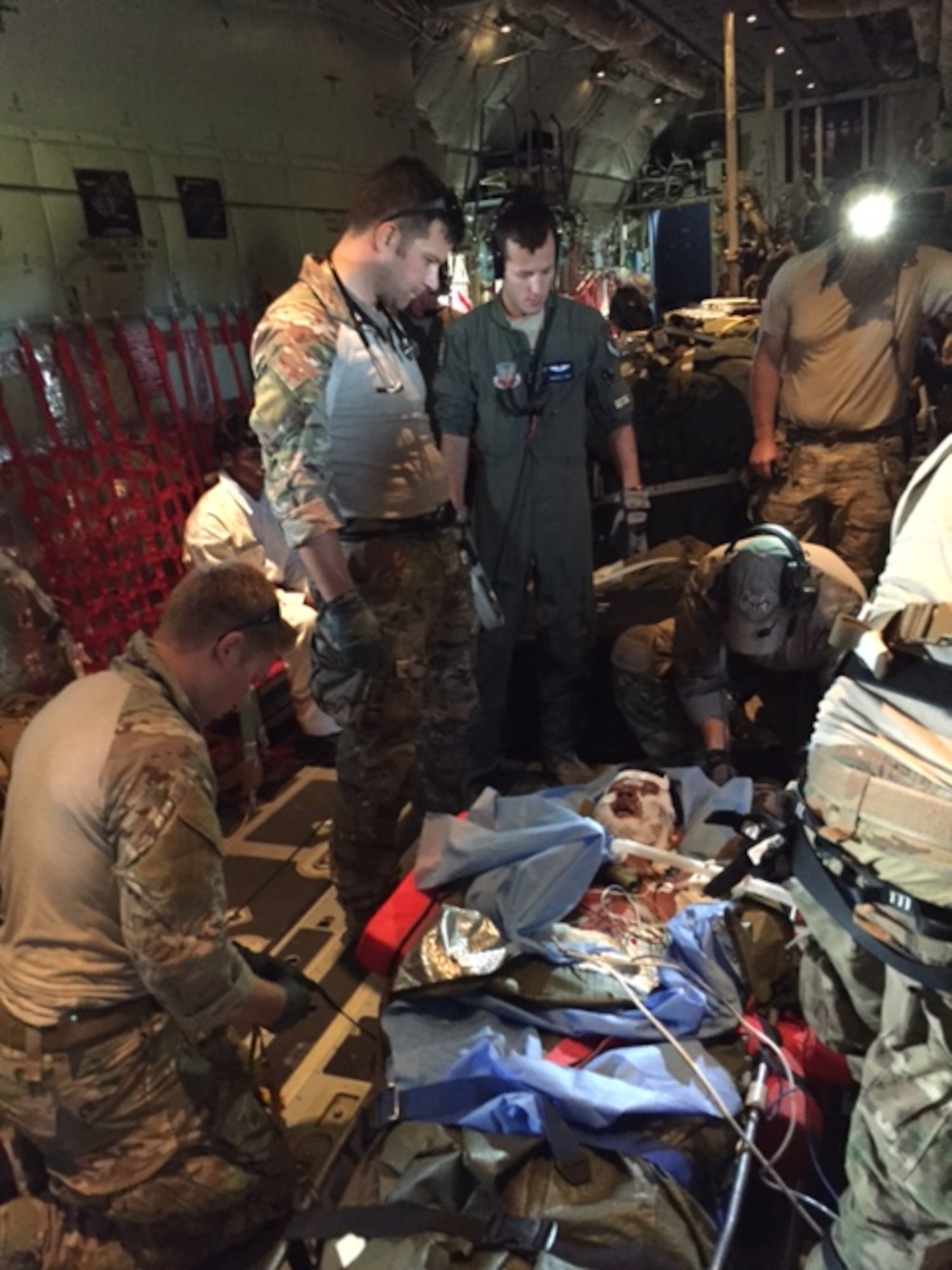 Maj. Alex Keller (left center), a surgeon with the 720th Special Tactics Group, supervises the medical treatment of a burn patient on an HC-130 Combat King II, June 23, 2016. Keller, alongside pararescuemen and aircrew from the 372nd Rescue Group, assisted in the rescue and evacuation of fishermen stranded off the shore of Bermuda when their vessel caught fire. (Courtesy photo) 