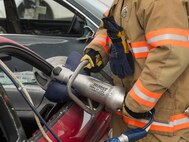A 5th Civil Engineer Squadron fire department member cuts the roof off a car during a demonstration at the Heroes in Training event at Minot Air Force Base, N.D., June 24, 2016. During the demonstration, fire fighters showed base children and their families tools, such as the Jaws of Life, and procedures used to rescue car crash victims. (U.S. Air Force photo/Airman 1st Class Christian Sullivan)