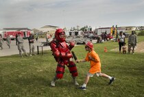 A Minot child uses a baton on a security forces member during Heroes in Training at Minot Air Force Base, N.D., June 24, 2016. Heroes in Training showcased displays from the fire department, security forces, medical group and other first responding base agencies. (U.S. Air Force photo/Airman 1st Class Christian Sullivan)