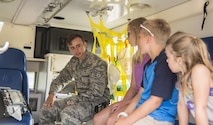 Senior Airman Nathan Jauch, 5th Medical Operations Support Squadron family health technician, explains his job and its importance to Minot children during Heroes in Training at Minot Air Force Base, N.D., June 24, 2016. Heroes in Training showcased displays from the fire department, security forces, medical group and other first responding base agencies. (U.S. Air Force photo/Airman 1st Class Christian Sullivan)