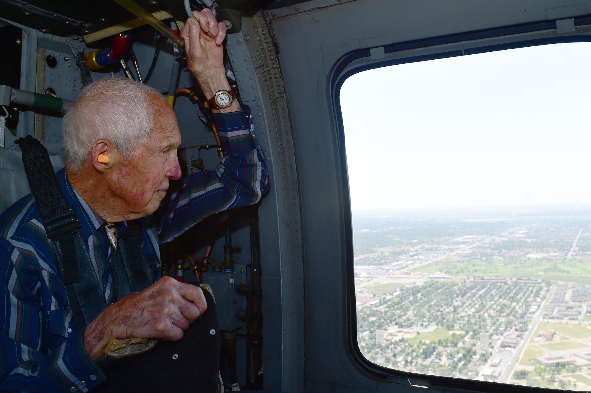 Ret. U.S. Air Force Col. Bill Myers looks out of a Sikorsky UH-60 Black Hawk helicopter window June 17, 2016, in Denver. Quick and Myers are both part of the Order of Daedalians, which honors WWI aviators as the first to fly United States aircraft in a time of war. The two men, now in their late 90’s, both served in WWII, Korea and Vietnam. Both men have a connection with Colorado. Quick flew out of Buckley Field during WWII and Myers was a part of the Colorado Air National Guard. (U.S. Air Force photo by Airman 1st Class Luke W. Nowakowski/Released)