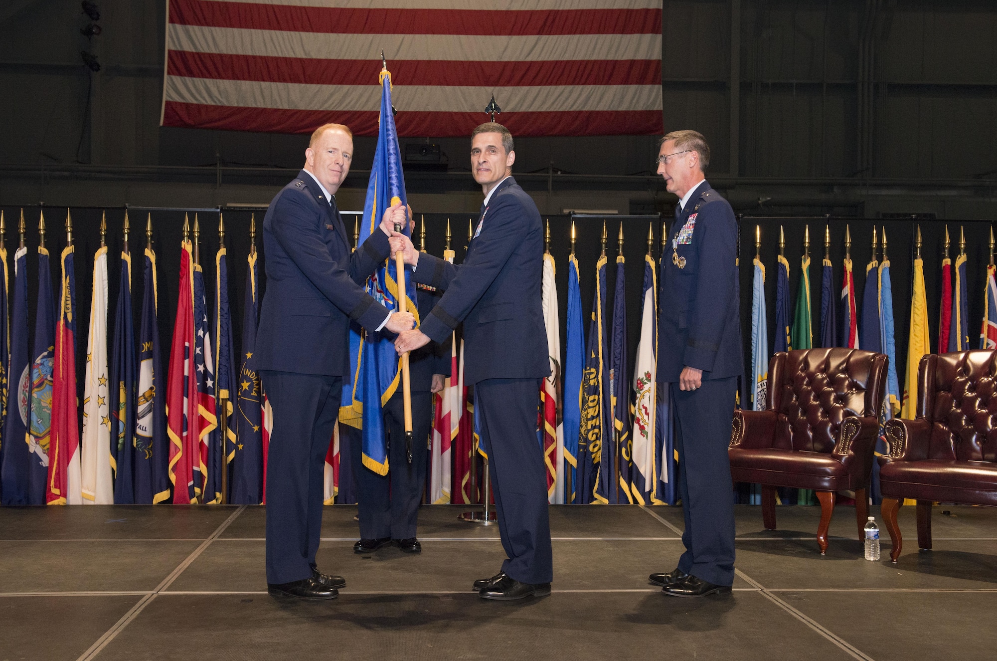 In the time-honored military tradition signifying assumption of command, Air Force Research Laboratory Commander Maj. Gen. Robert D. McMurry passes the 711th Human Performance Wing guidon, or unit flag, to Brig. Gen. Mark A. Koeniger. Koeniger assumed command of the wing Jun. 28, 2016, in a ceremony at the National Museum of the United States Air Force. (U.S. Air Force photo/Michelle Gigante) 