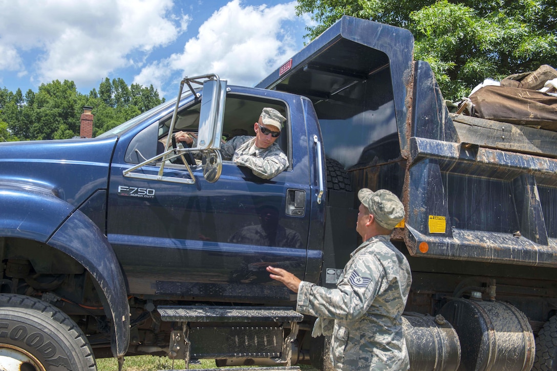 Air Force Tech. Sgts. Caleb Brown, top, and Brian Gatens discuss debris removal during flood cleanup in Elkview, W.Va., June 28, 2016. Brown and Gatens are assigned to the West Virginia Air National Guard’s 130th Airlift Wing. Air National Guard photo by Tech. Sgt. De-Juan Haley