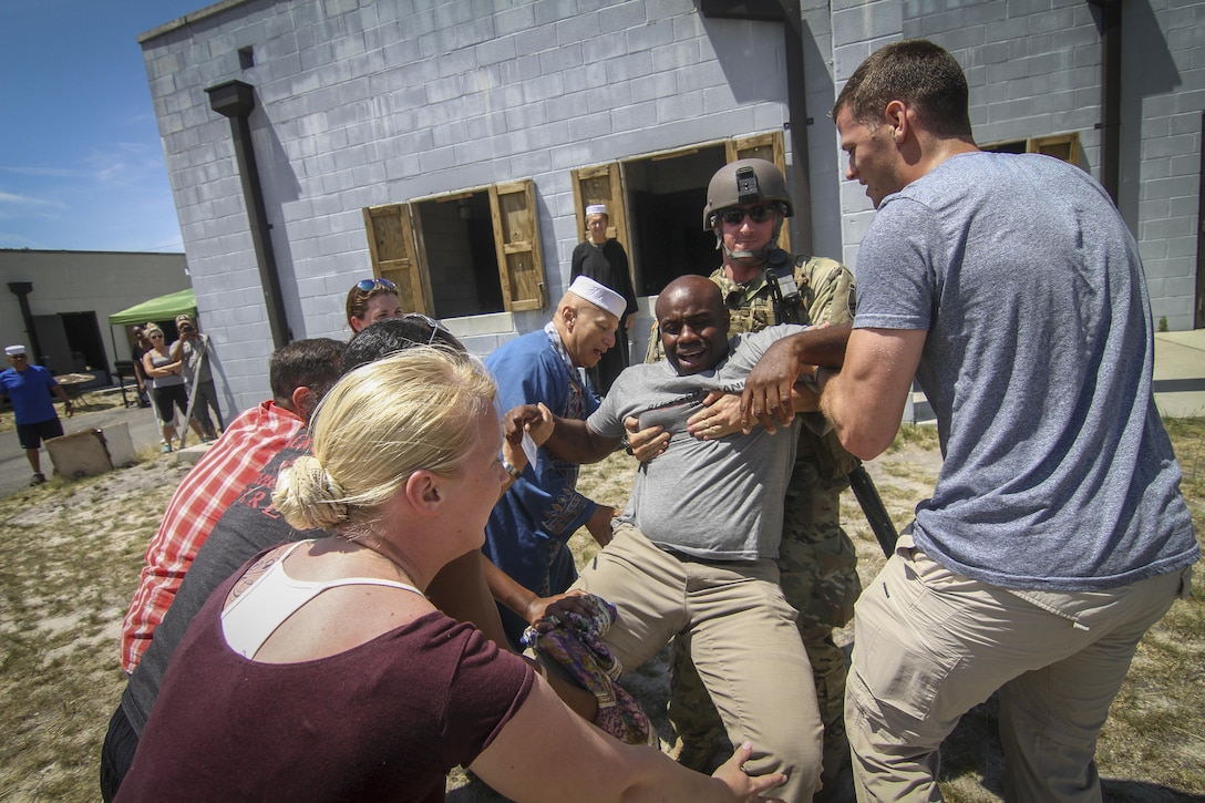 U.S. Army Reserve Staff Sgt. Anton Allsop, center, from the 404th Civil Affairs Battalion, acts as a wounded town mayor during Exercise Gridiron at Joint Base McGuire-Dix-Lakehurst, N.J., June 27, 2016. The 404th Civil Affairs Battalion used an urban training area and an array of actors to create a realistic village. (U.S. Air National Guard photo by Tech. Sgt. Matt Hecht/Released)