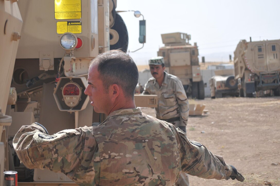 Army Sgt. Aaron James, left, a trainer with Headquarters and Headquarters Company, 2nd Battalion, 502nd Infantry Regiment, Task Force Strike, demonstrates to a Peshmerga soldier how to signal to properly hook a tow winch to another vehicle during vehicle recovery training in Erbil, Iraq, June 22, 2016. Iraqi fighters have begun shaping operations in preparation for the operation to retake Mosul from Islamic State of Iraq and the Levant terrorists, the Operation Inherent Resolve spokesman said June 29, 2016.. Army photo by 1st Lt. Daniel Johnson