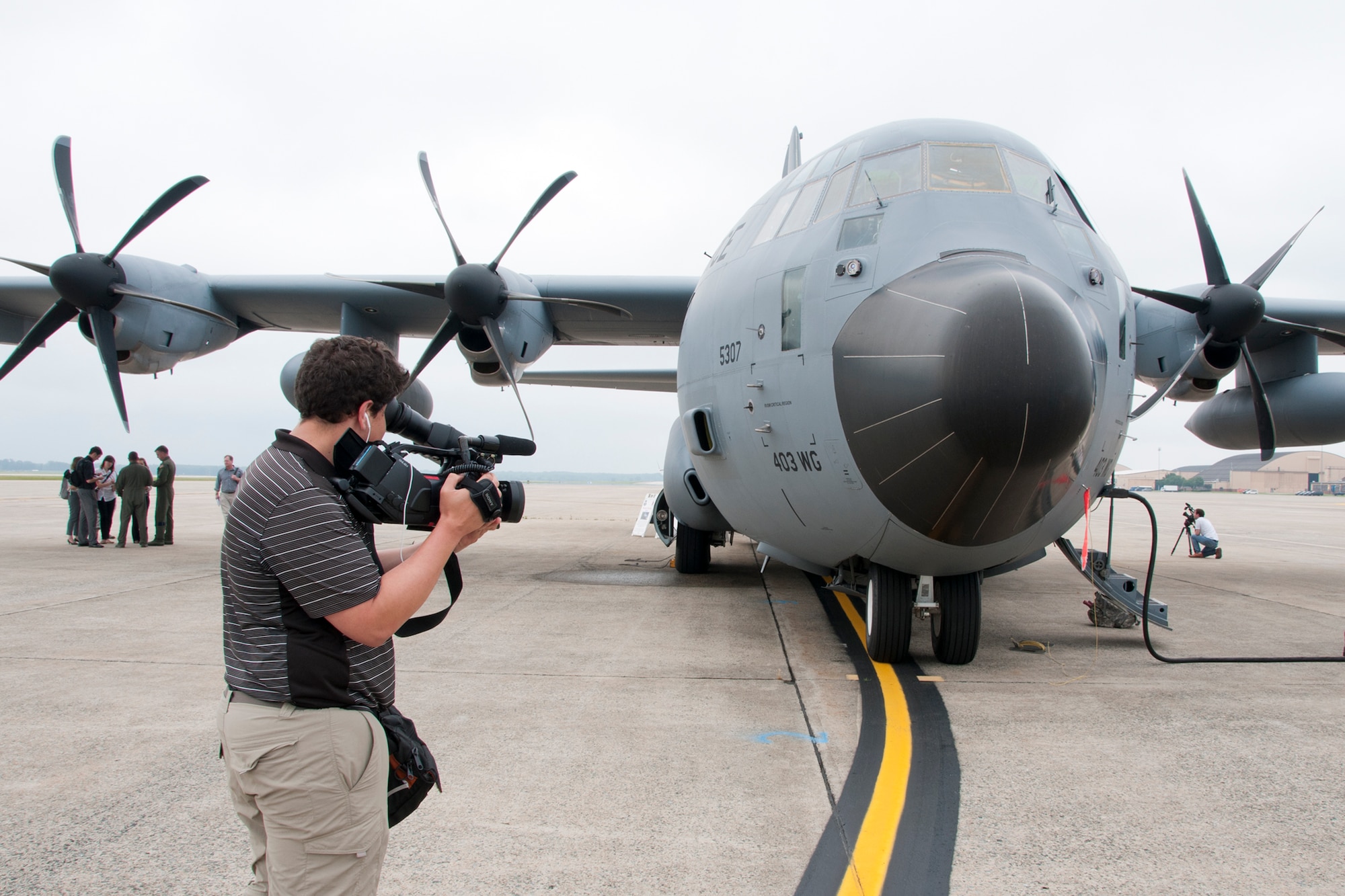 Daniel Wolfolk, Air Force Times videographer, captures footage of a C-130 Hercules on the Joint Base Andrews, Md., flight line June 28, 2016. In honor of the 100th anniversary of U.S. air reserve power, media members were invited to an event showcasing special missions conducted by C-130s in Air Force Reserve Command, to include weather surveillance, firefighting and aerial spraying. (U.S. Air Force photo/Staff Sgt. Kat Justen)