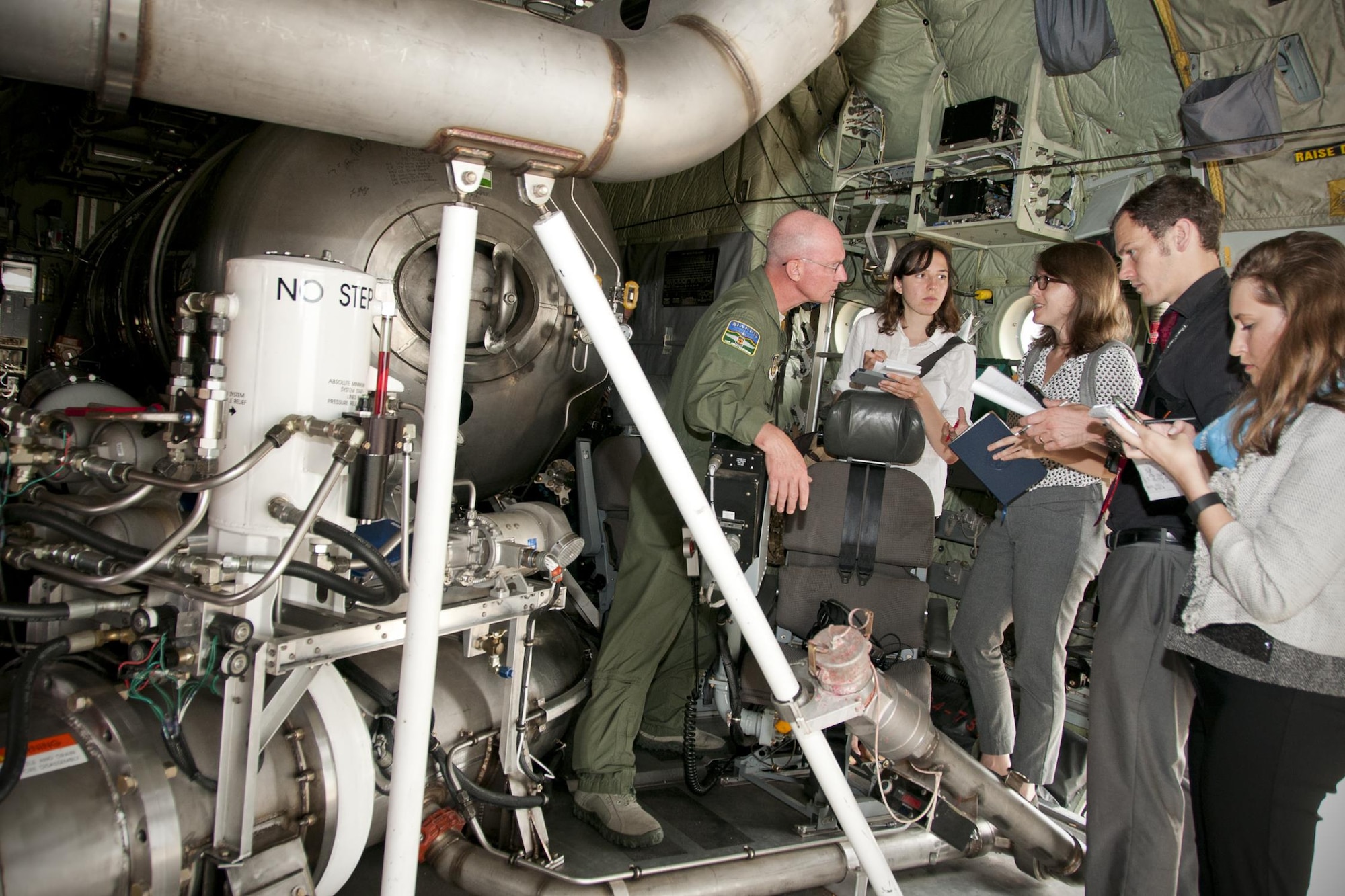 Master Sgt. Tom Freeman, 302nd Airlift Wing loadmaster (left), describes his unit’s specialized mission of aerial firefighting employing the U.S. Forest Service's Modular Airborne Fire Fighting Systems to a group of media members on the Joint Base Andrews, Md., flight line June 28, 2016. In honor of the 100th anniversary of U.S. air reserve power, media members were invited to an event showcasing special missions conducted by C-130s in Air Force Reserve Command, to include weather surveillance, firefighting and aerial spraying. (U.S. Air Force photo/Staff Sgt. Kat Justen)