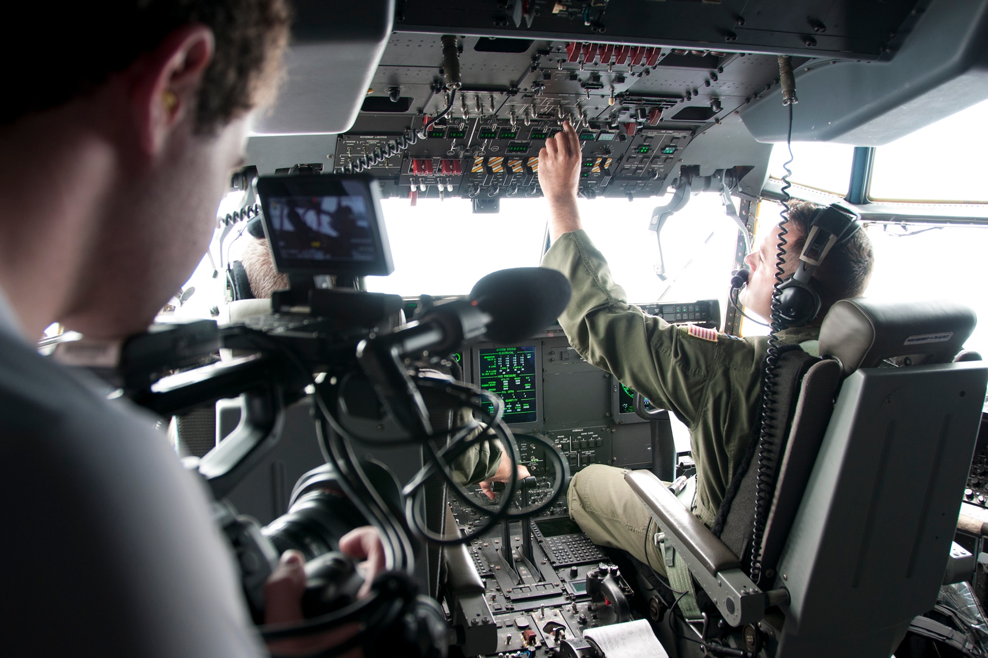 Thom Patterson, CNN videographer (left), uses a camera to capture footage of 53d Weather Reconnaissance Squadron “Hurricane Hunter” pilots inside the cockpit of a C-130 Hercules during a flight over Maryland June 28, 2016. As part of the 100th anniversary of air power in the U.S. military, members of the media were invited to fly with the Hurricane Hunters and learn about their weather surveillance mission. With ten deployable C-130s, the unit has the only routine aerial weather reconnaissance mission in the world. (U.S. Air Force photo/Staff Sgt. Kat Justen)