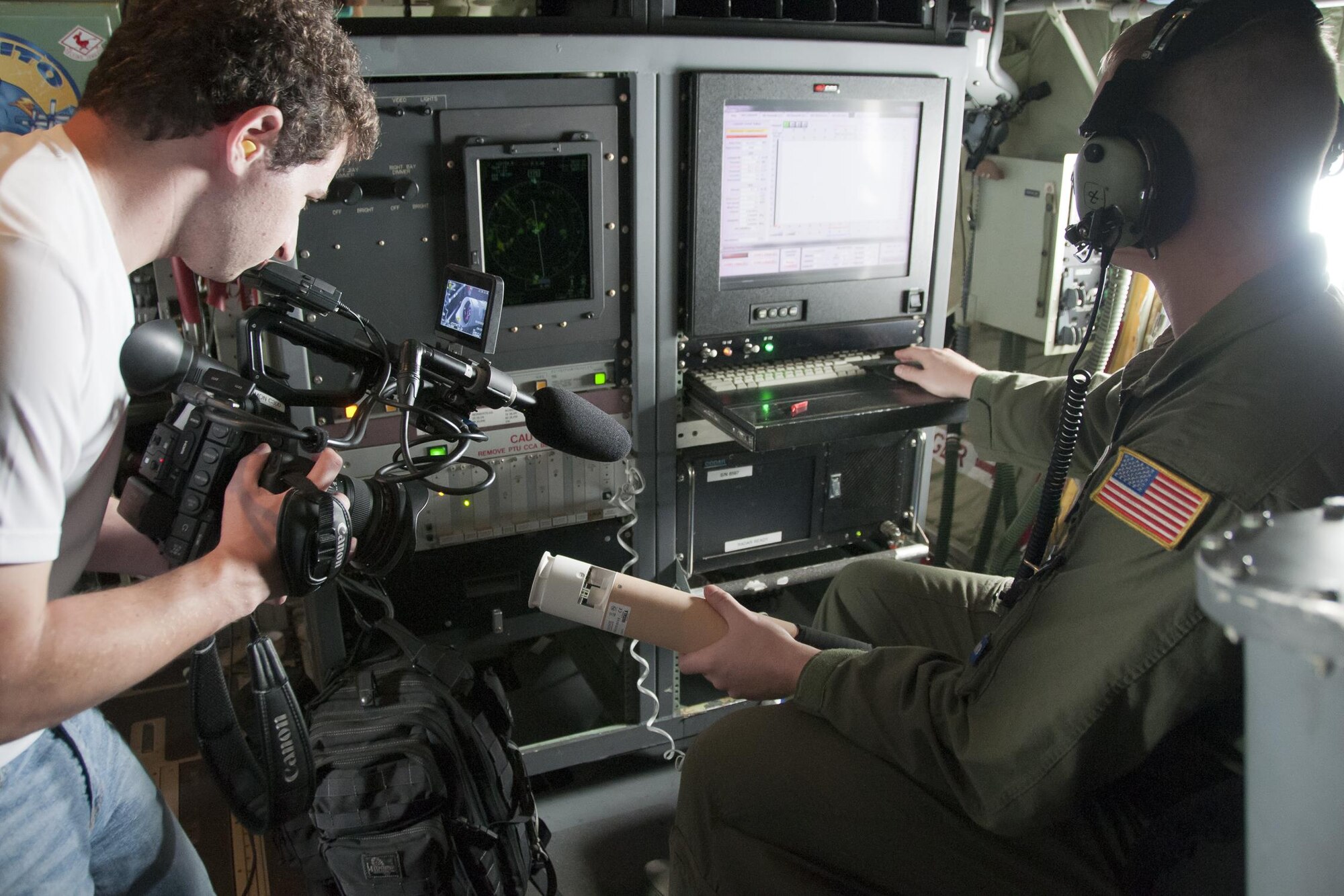 Thom Patterson, CNN videographer (left), uses a camera to capture footage of a dropsonde inside a 53d Weather Reconnaissance Squadron Hurricane Hunters C-130 Hercules during a flight over Maryland June 28, 2016. A dropsonde is used by the Hurricane Hunters to collect temperature, humidity, wind speed and direction of weather systems. The information is then sent to the National Hurricane Center in Miami to monitor tropical storms. As part of the 100th anniversary of air power in the U.S. military, members of the media were invited to fly with the Hurricane Hunters and learn about their weather surveillance mission. With ten deployable C-130s, the unit has the only routine aerial weather reconnaissance mission in the world. (U.S. Air Force photo/Staff Sgt. Kat Justen) 
