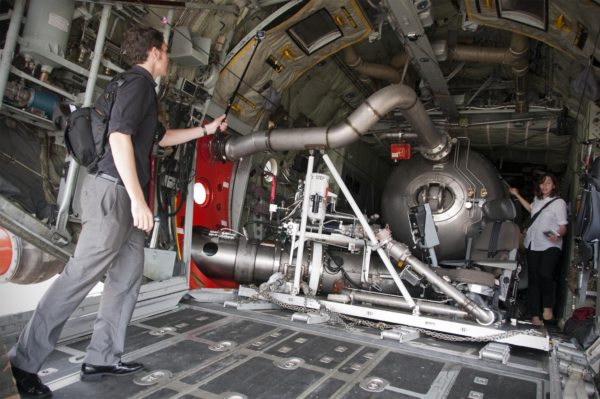 James Drew, Aviation Week defense editor (left), captures footage with a handheld camera of the S-duct fire suppression system inside a 302nd Airlift Wing C-130 Hercules on the Joint Base Andrews, Md., flight line June 28, 2016. In honor of the 100th anniversary of U.S. air reserve power, media members were invited to an event showcasing special missions conducted by C-130s in the Air Force Reserve Command, to include weather surveillance, firefighting and aerial spraying. (U.S. Air Force photo/Staff Sgt. Kat Justen)