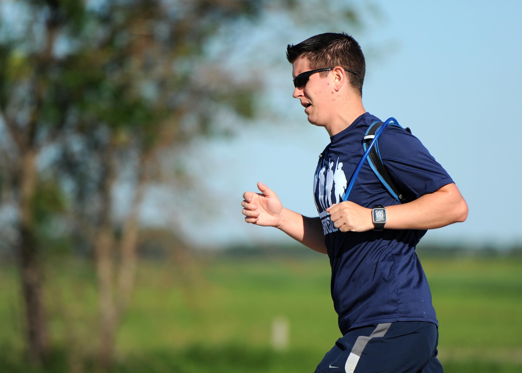 Staff Sgt. Brendan Brustad, 319th Air Base Wing assistant to the wing executive officer, grips his portable hydration device during a run June 29, 2016, in Grand Forks, N.D. Brustad ran at least 22 miles a day for the entire month of June to raise awareness for post-traumatic stress disorder. (U.S. Air Force photo by Senior Airman Ryan Sparks/Released)