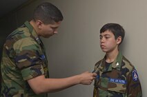Civil Air Patrol 2nd Lt. Brock Atchley, CAP bravo flight tactical officer, measures a rank insignia on a cadet during a uniform inspection at the CAP summer encampment at Yokota Air Base, Japan, June 25, 2016. In addition to the uniform inspection, the cadets also received a dorm inspection. (U.S. Air Force photo by Senior Airman David Owsianka/Released)