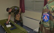 Civil Air Patrol 2nd Lt. Brock Atchley, CAP bravo flight tactical officer, measures the length of a folded t-shirt during a dorm inspection at the CAP summer encampment at Yokota Air Base, Japan, June 23, 2016. Throughout the week-long encampment, the cadets went through a stringent schedule that consisted of formations, physical training, uniform and room inspections, marching in formation, classes and visiting various squadrons throughout the base. (U.S. Air Force photo by Senior Airman David Owsianka/Released)