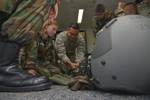 Senior Airman Kenny Batallas, 374th Operations Support Squadron aircrew flight equipment journeyman, goes over the aircrew chemical defense ensemble with cadets from the Civil Air Patrol summer encampment at Yokota Air Base, Japan, June 23, 2016. The cadets visited various sections such as the 374th Maintenance Squadron propulsion flight, 374th Operations Support Squadron aircrew flight equipment, 374th Security Forces Squadron combat arms training and maintenance, and the 730th Air Mobility Squadron (U.S. Air Force photo by Senior Airman David Owsianka/Released)
