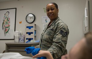 U.S. Air Force Staff Sgt. Ashley Williams, 633rd Surgical Squadron women’s health non-commissioned officer in charge, comforts a patient during a routine pap smear examine at Langley Air Force Base, Va., June 24, 2016. The clinic provides patients with services such as mammograms and cervical cancer examines. (U.S. Air Force photo by Airman 1st Class Kaylee Dubois)