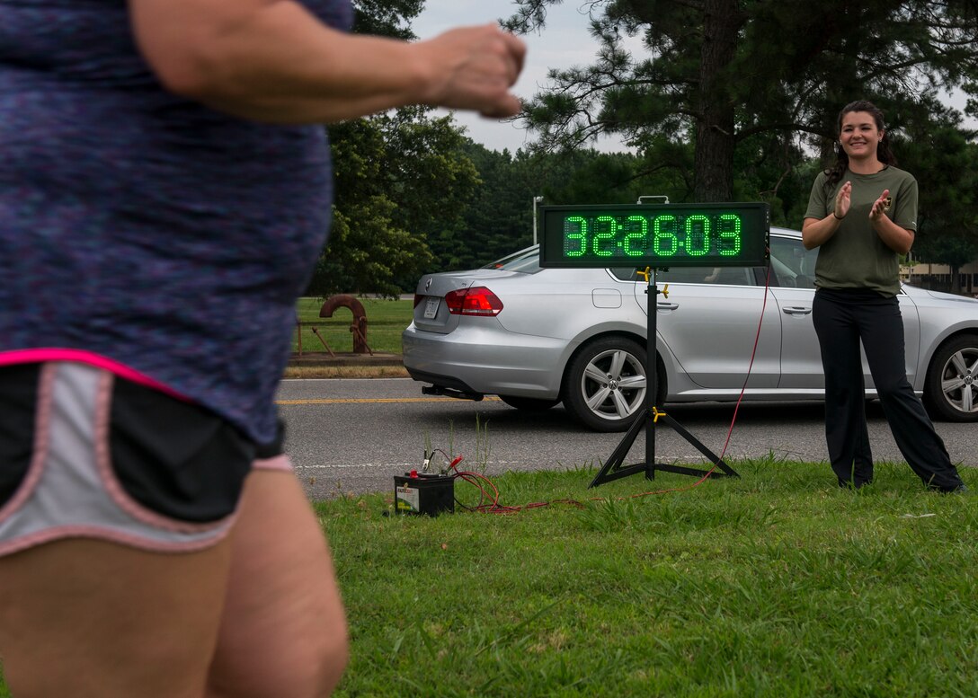 Kellie Jorgensen, 633rd Force Support Squadron fitness center director, cheers on a runner crossing the finish line during the final 5K run for the Civilian Commanders Cup Fitness Challenge at Fort Eustis, Va., June 23, 2016. About 83 civilian employees, their U.S. service member counterparts and their families participated in the six-month challenge. (U.S. Air Force photo by Airman 1st Class Derek Seifert)
