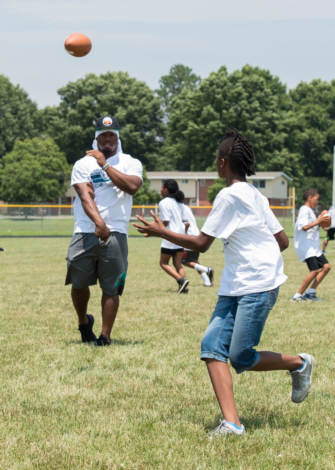Carolina Panthers running back Jonathan Stewart throws a pass to a child during a football Pro Camp at Fort Eustis, Va., June 21, 2016. About 150 participants that attended the two-day camp got the opportunity to interact with a professional football player and military child. (U.S. Air Force photo by Airman 1st Class Derek Seifert)