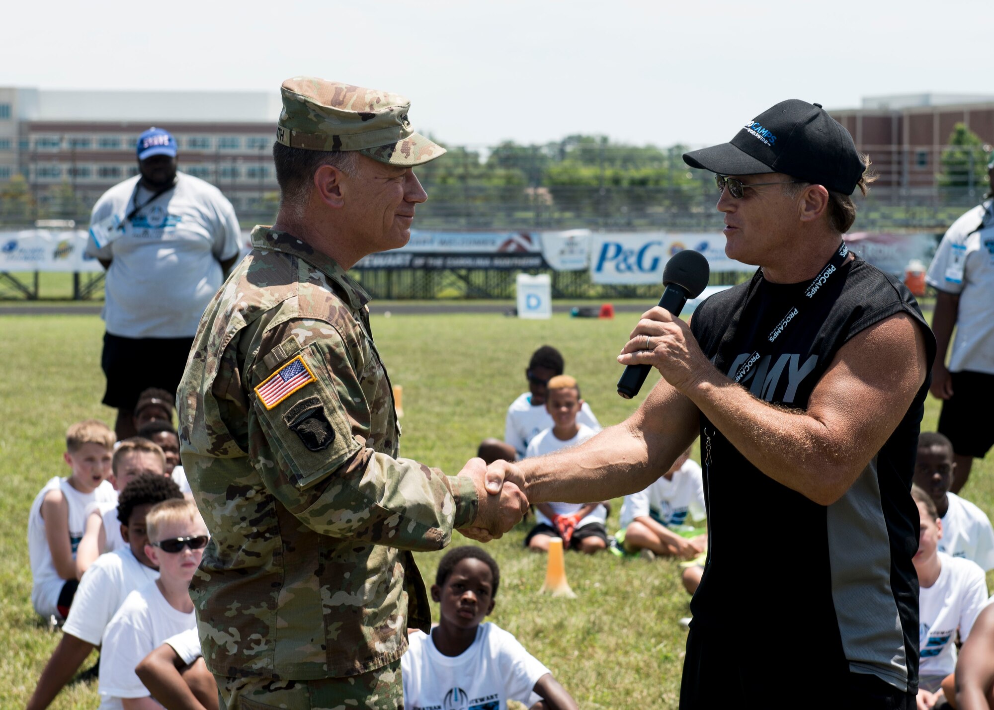 U.S. Army Col. William Galbraith, 733rd Mission Support Group commander, shakes hands with a Proctor and Gamble representative during a football Pro Camp at Fort Eustis, Va., June 21, 2016. The camp gave about 150 children the opportunity to learn drills and techniques from Carolina Panthers running back Jonathan Stewart. (U.S. Air Force photo by Airman 1st Class Derek Seifert)