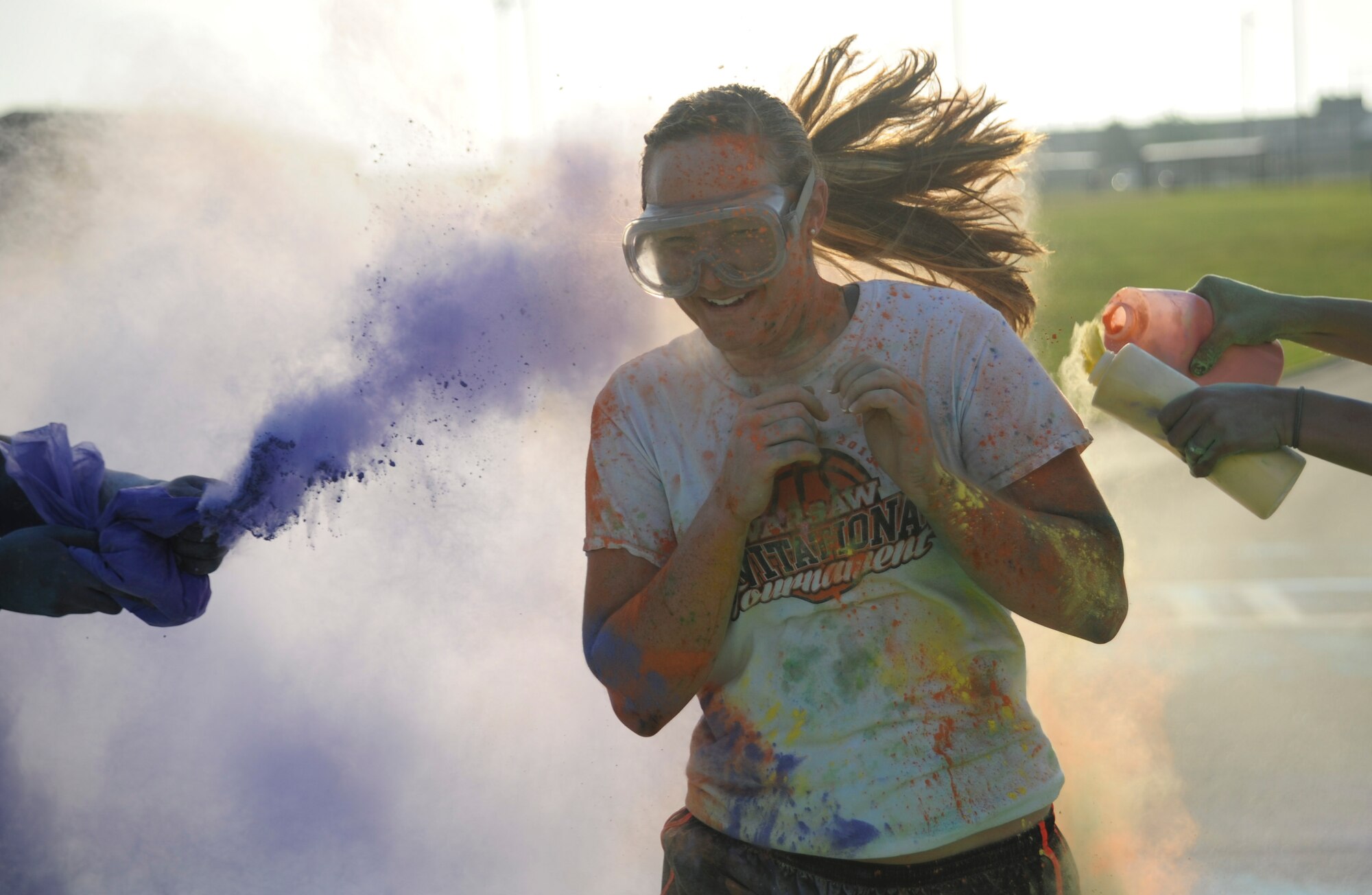 A participant runs as volunteers throw colored powder on her during the Lesbian, Gay, Bisexual and Transgender (LGBT) Pride Month Rainbow Run 5K at Whiteman Air Force Base, Mo., June 24, 2016. The run promoted the 2016 theme of “celebration.” (U.S. Air Force photo by Senior Airman Danielle Quilla)