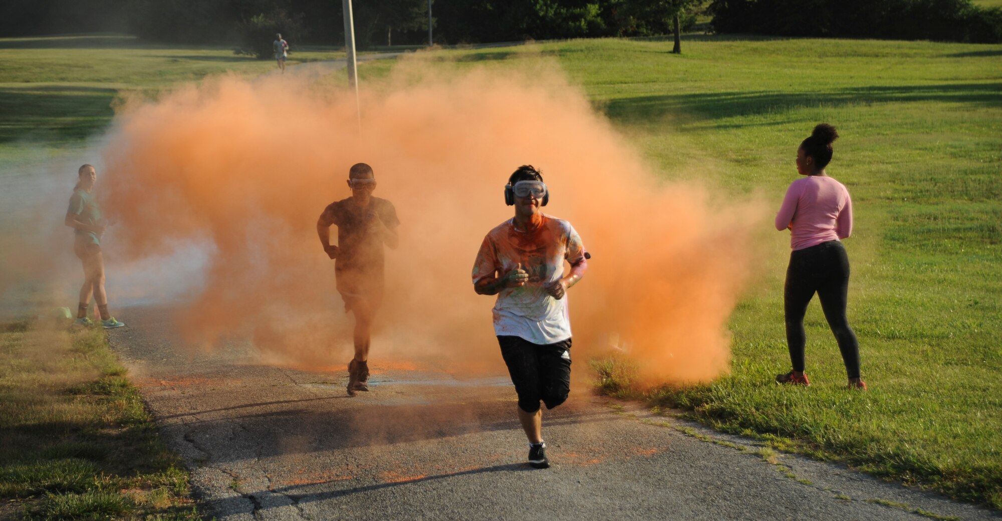 Participants run through a cloud of colored powder during the Lesbian, Gay, Bisexual and Transgender Pride Month Rainbow Run 5K at Whiteman Air Force Base, Mo., June 24, 2016. After the run, the 509th Civil Engineer Squadron fire department washed the powder from the streets. (U.S. Air Force photo by Senior Airman Danielle Quilla)