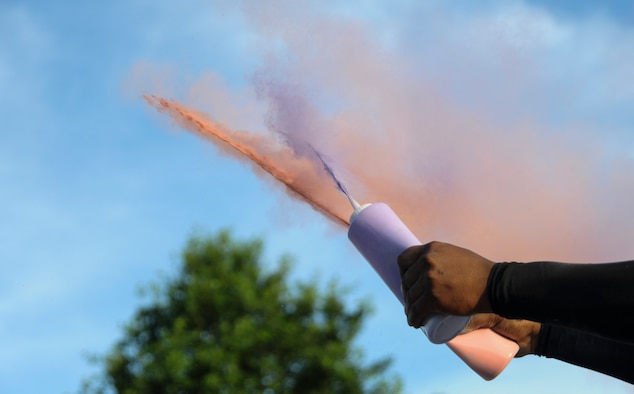A volunteer sprays colored powder at runners during the Lesbian, Gay, Bisexual and Transgender Pride Month Rainbow Run 5K at Whiteman Air Force Base, Mo., June 24, 2016. A total of 28 volunteers helped setup the event and run the color stations. (U.S. Air Force photo by Senior Airman Danielle Quilla)