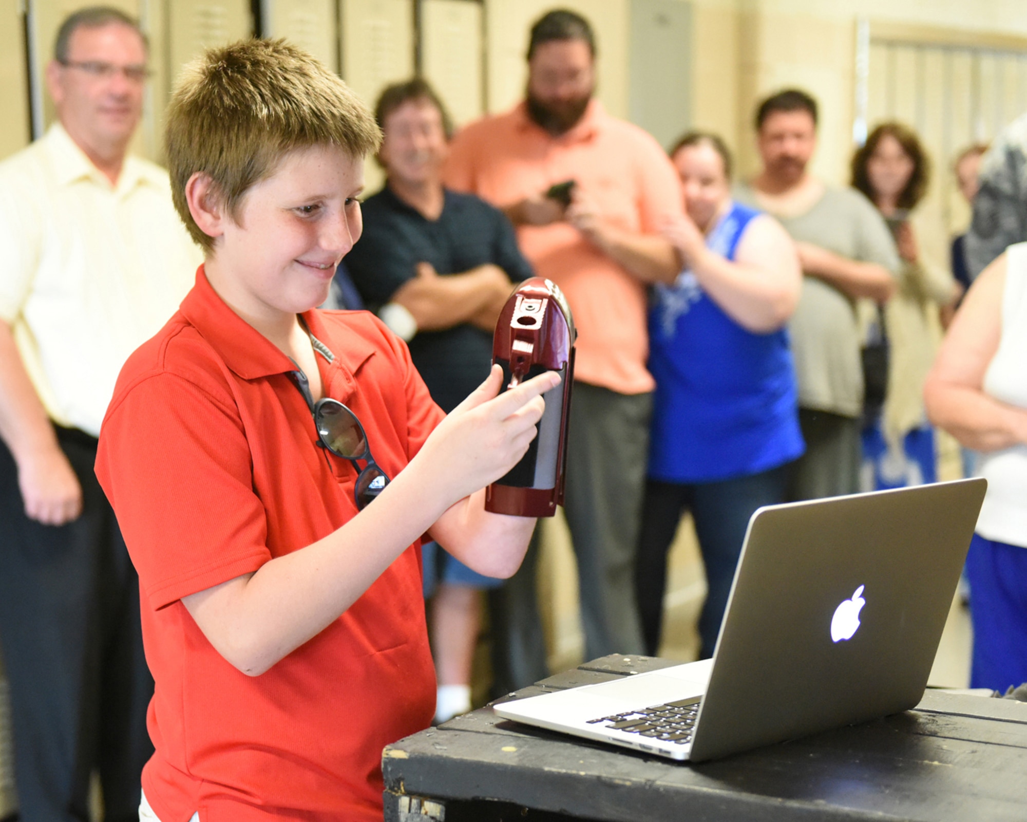 Andrew (A.J.) Mindy shows his mother, Senior Master Sgt. Susan Mindy, a member of Joint Force Headquarters Pennsylvania National Guard, via Skype, his new prosthetic attachment that holds a drum stick, June 7, 2016 at the Pine Grove Area High School, Pine Grove, Penn.  With the ability to hold three attachments, the prosthetic was presented by a high school freshman Nick Brown, the designer of the 3D printed device.  Sgt. Mindy has been deployed for four months.  (U.S. Air National Guard photo by Master Sgt. Matt Schwartz/Released)