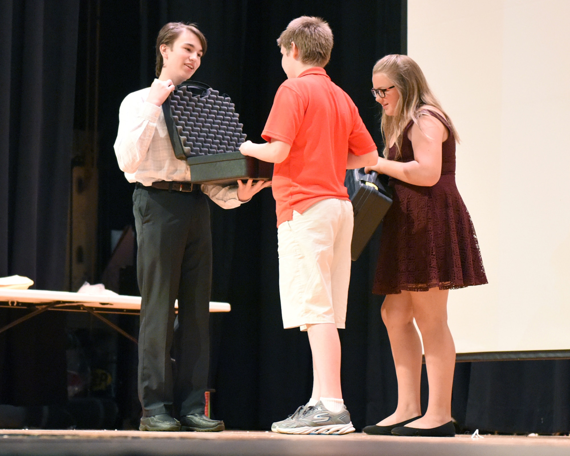 Nick Brown, a freshman at Pine Grove Area High School, Pine Grove, Penn., presents a 3D printer prosthetic device that he designed to Andrew (A.J.) Mindy, a middle school student and son to Pennsylvania Air National Guardsmen Senior Master Sgt. Susan Mindy, who is currently deployed June 7, 2016.  Sgt. Mindy was Skyped into the presentation that will allow her son who was born with only one hand to be able to play musical instruments and continue being a musician. (U.S. Air National Guard photo by Master Sgt. Matt Schwartz/Released)