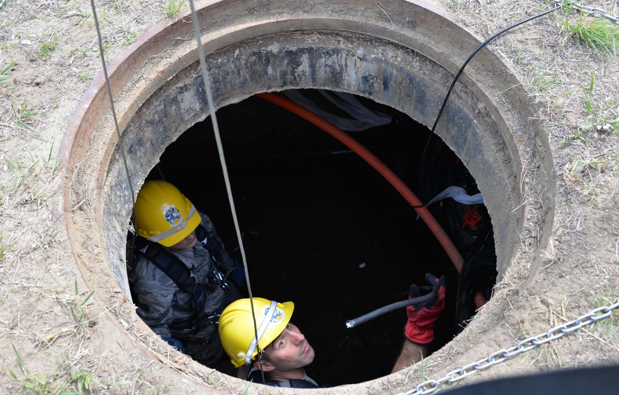 Senior Airmen Chris Ouellette, 243rd Engineering Installation Squadron airfield systems technician, removes outdated coaxial cable and obsolete fiber optic cable from various manholes at Pease Air National Guard Base, N.H., June 17. The team from Portland, M.E. has assisted the 157th Communications Flight with removing over 20,000 feet of cable from manholes at Pease ANGB. (U.S. Air National Guard photo by Tech. Sgt. Erica Rowe)