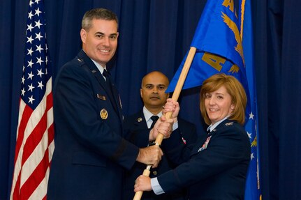 Col. Dawn C. Lancaster takes the guidon from Brig. Gen. Lenny J. Richoux, Director of Air Force Services, Headquarters U.S. Air Force, Washington, D.C., during a change of command ceremony June 28, 2016, at The Landings on Dover Air Force Base, Del. Lancaster is the new Air Force Mortuary Affairs Operations commander. (U.S. Air Force photo/Roland Balik)
