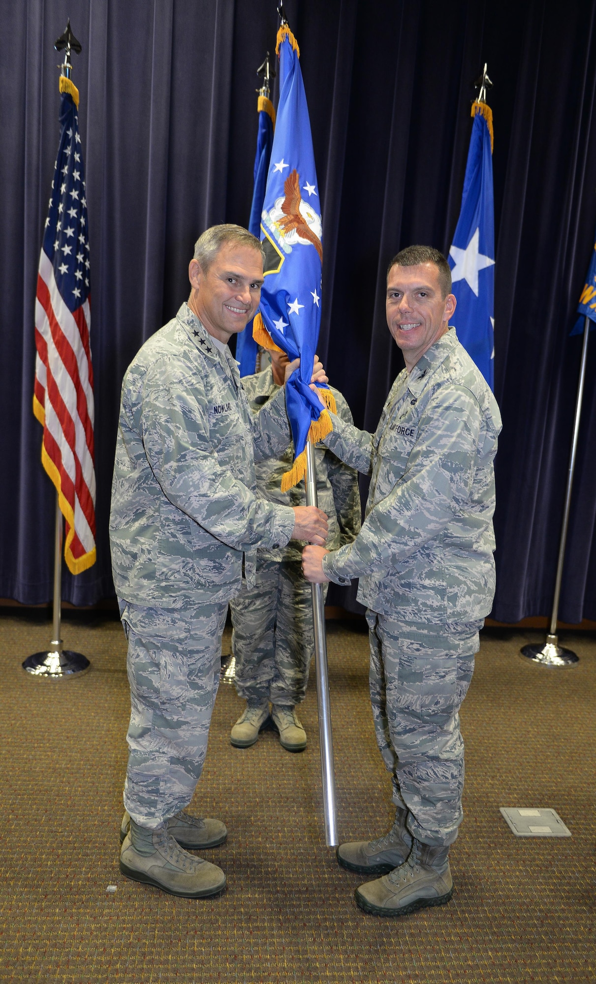 U.S. Air Force Lt. Gen. Mark C. Nowland, 12th Air Force (Air Forces Southern) commander, hands the 557th Weather Wing guidon to U.S. Air Force Col. Steven Dickerson, during a change of command ceremony at the 557th WW Auditorium June 24. Dickerson took command from U.S. Air Force Col. William Carle. (U.S. Air Force photo by Zachary Hada)