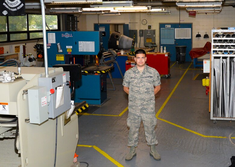 Airman 1st Class Robert Wierzbicki poses in the sheet metal shop surrounded by the equipment they use daily to provide metal used for the A-10 June 22, 2016 at Warfield Air National Guard Base, Middle River, Md. Wierzbicki is the Maryland Air National Guard July Spotlight Airman. (U.S. Air National Guard photo by Airman 1st Class Enjoli Saunders/RELEASED) 