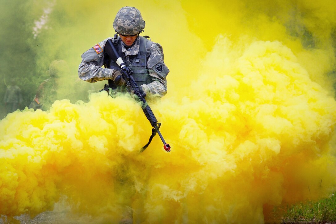 Army Pfc. Richard Burger runs through smoke marking a simulated casualty extraction point during the Ready Warrior Competition at Camp Madbull at Joint Base Elmendorf-Richardson, Alaska, June 23, 2016. Burger is assigned to the 574th Quartermaster Company, 17th Combat Sustainment Support Battalion. Air Force photo by Justin Connaher