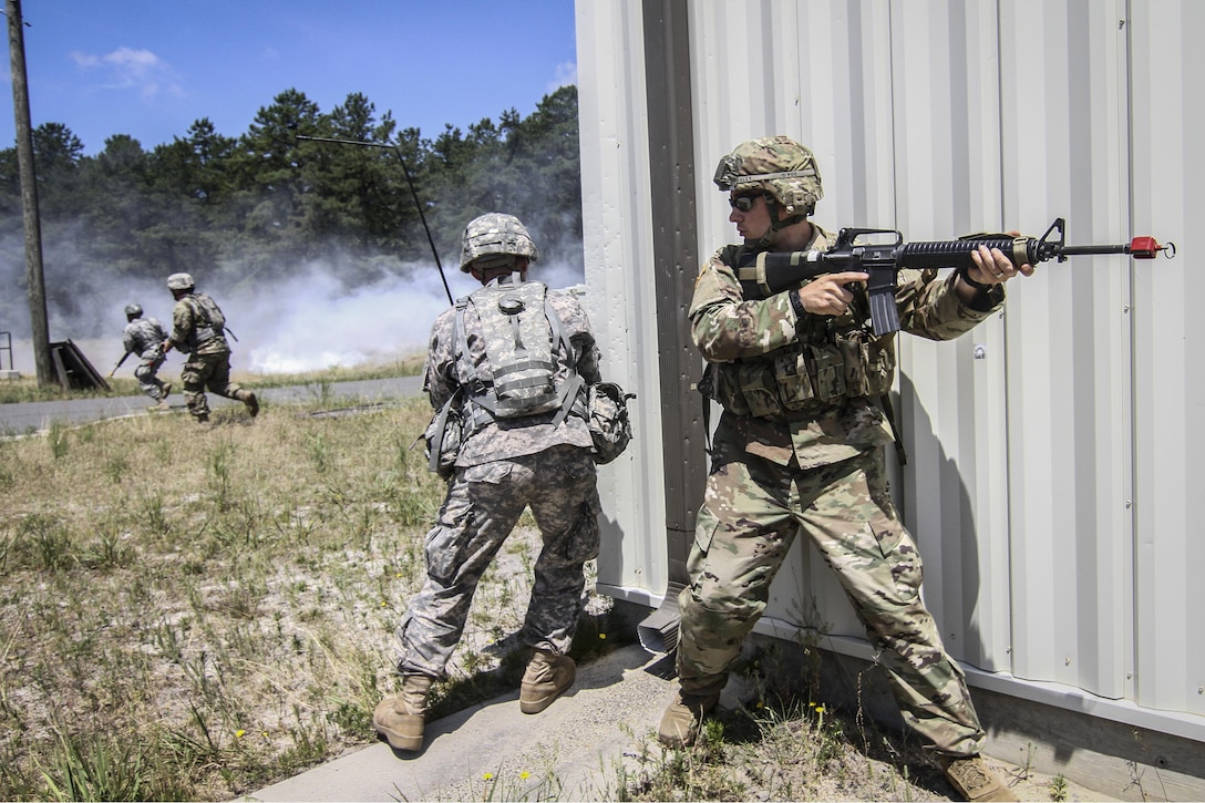 Soldiers provide cover for one another while crossing a field under simulated enemy fire during Exercise Gridiron at Joint Base McGuire-Dix-Lakehurst, N.J., June 27, 2016. The soldiers are reservists assigned to the 404th Civil Affairs Battalion. Air National Guard photo by Tech. Sgt. Matt Hecht