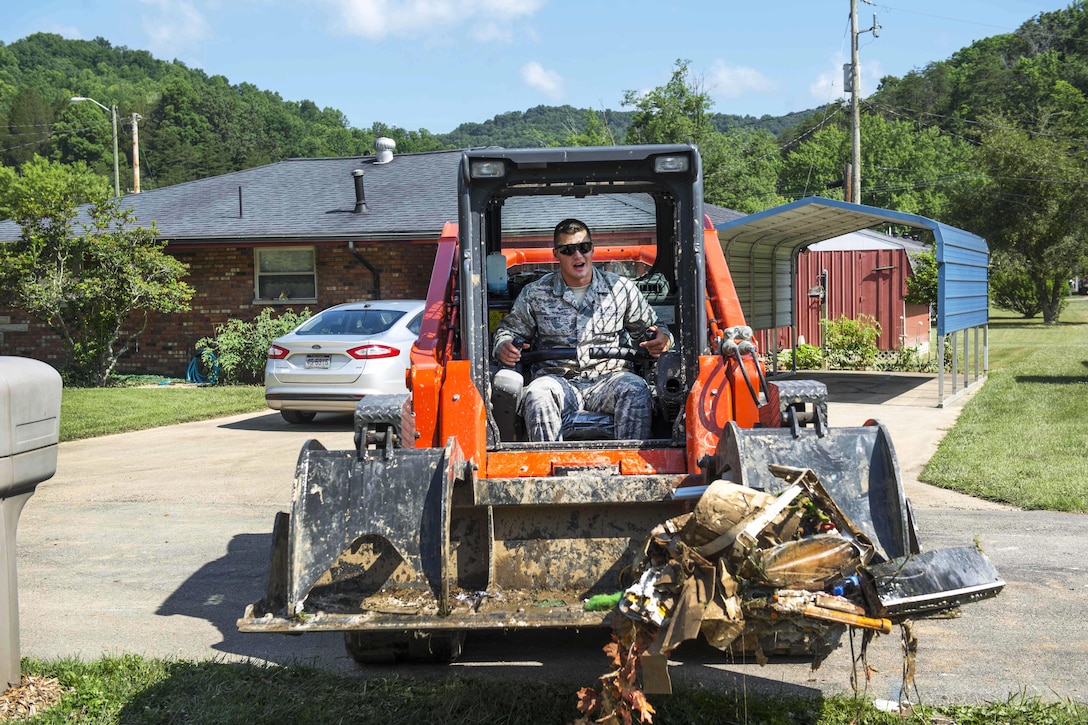 Air Force Senior Airman Logan Mahaney operates a loader to collect debris during flood cleanup in Elkview, W.Va., June 28, 2016. Mahaney is assigned to the West Virginia Air National Guard’s 130th Airlift Wing. Air National Guard photo by Tech. Sgt. De-Juan Haley