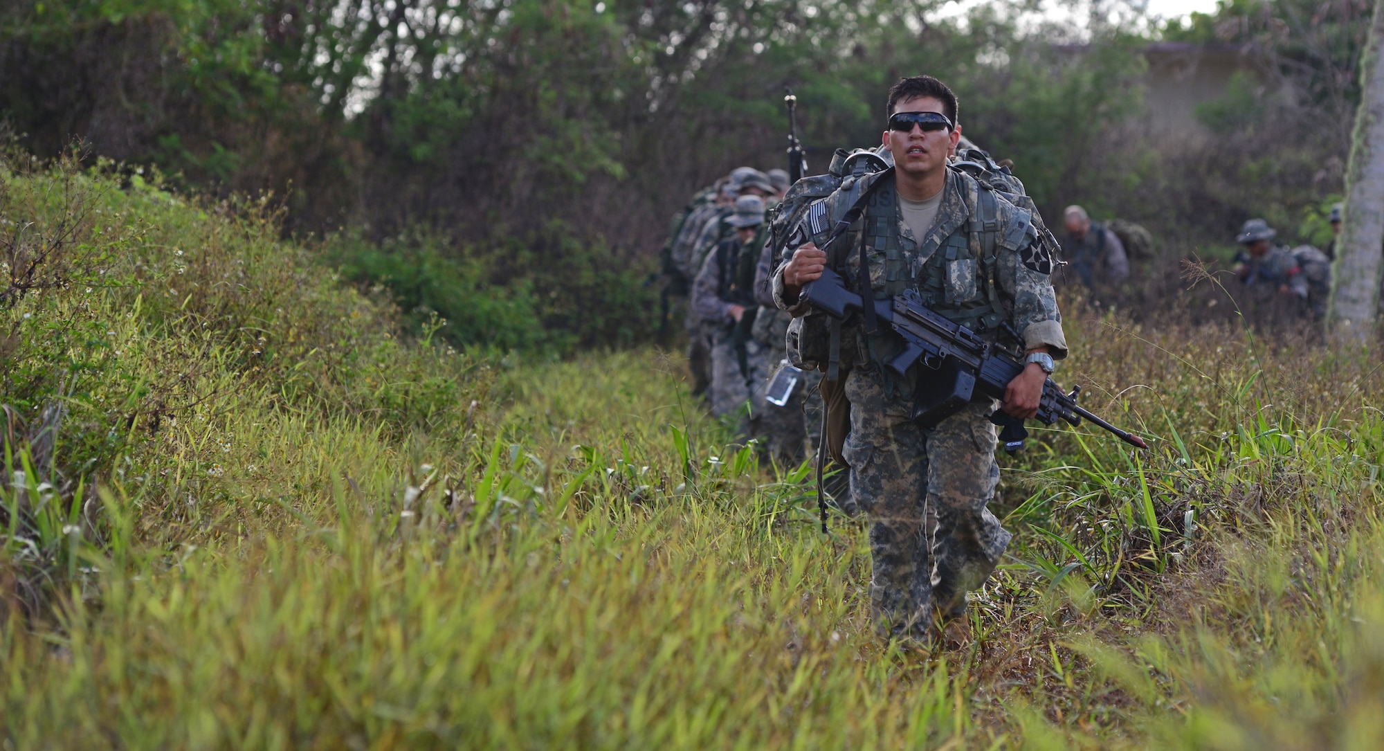 Soldiers and Airmen ruck to an objective point during the Jungle Training Operations Course June 16, 2016, in Barrigada, Guam. Conducted by the U.S. Army 25th Infantry Division's Lightning Academy Jungle Operations Training Center from Schofield Barracks, Hawaii, and supported by 736th Security Forces Squadron Commando Warrior cadre, students prepared a simulated patient for medical evacuation. During the course, they also learned survival skills, including land navigation and evasion techniques. (U.S. Air Force photo by Senior Airman Joshua Smoot)