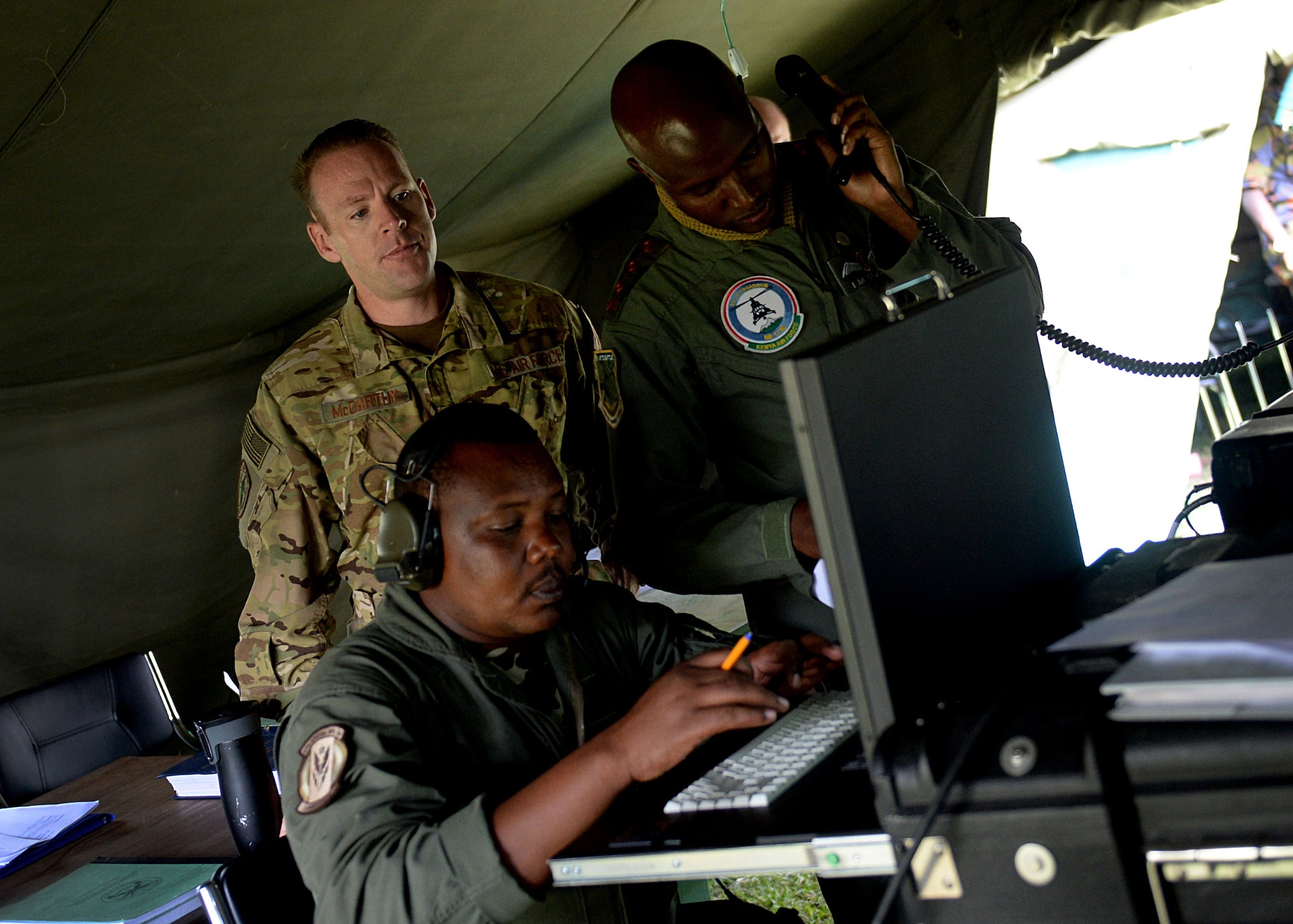 U.S. Air Force Maj. Christopher McCarthy, HH-60G helicopter evaluator pilot, 56th Rescue Squadron, observes Kenyan Defense Force members during African Partnership Flight Kenya June 27, 2016 at Laikipia Air Base, Kenya. The APF is designed for U.S. and African partner nations to work together in a learning environment to help build expertise and professional knowledge and skills. The APF included a Kenyan-led exercise, Linda Rhino, in which instructors observed the application of what was learned in the classroom and provided feedback. The exercise included multiple personnel recovery scenarios. (U.S. Air Force photo by Tech. Sgt. Evelyn Chavez/Released)