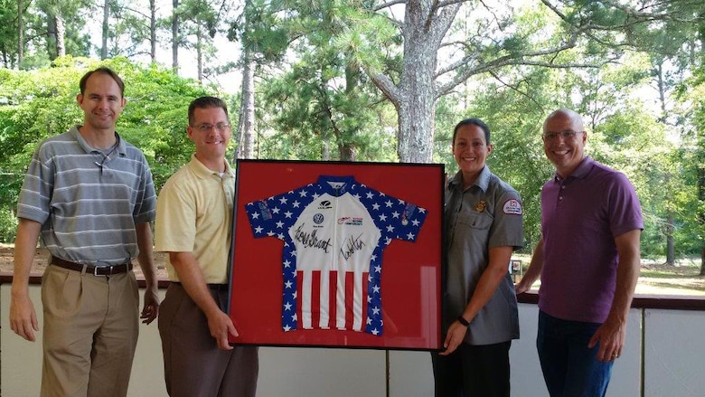 Aaron Wahus (second from left), park operations manager at J. Strom Thurmond Project, gathers with colleagues to display a framed jersey signed by men and women winners of the 2015 USA Cycling National Marathon Mountain Bike Championship hosted at Thurmond Lake. Other staff pictured from left to right include Scott Hyatt, Thurmond Project operations project manager, Christina Alford, recreation chief ranger and Randy Duteau, director of the Columbia County Convention and Visitors Bureau.