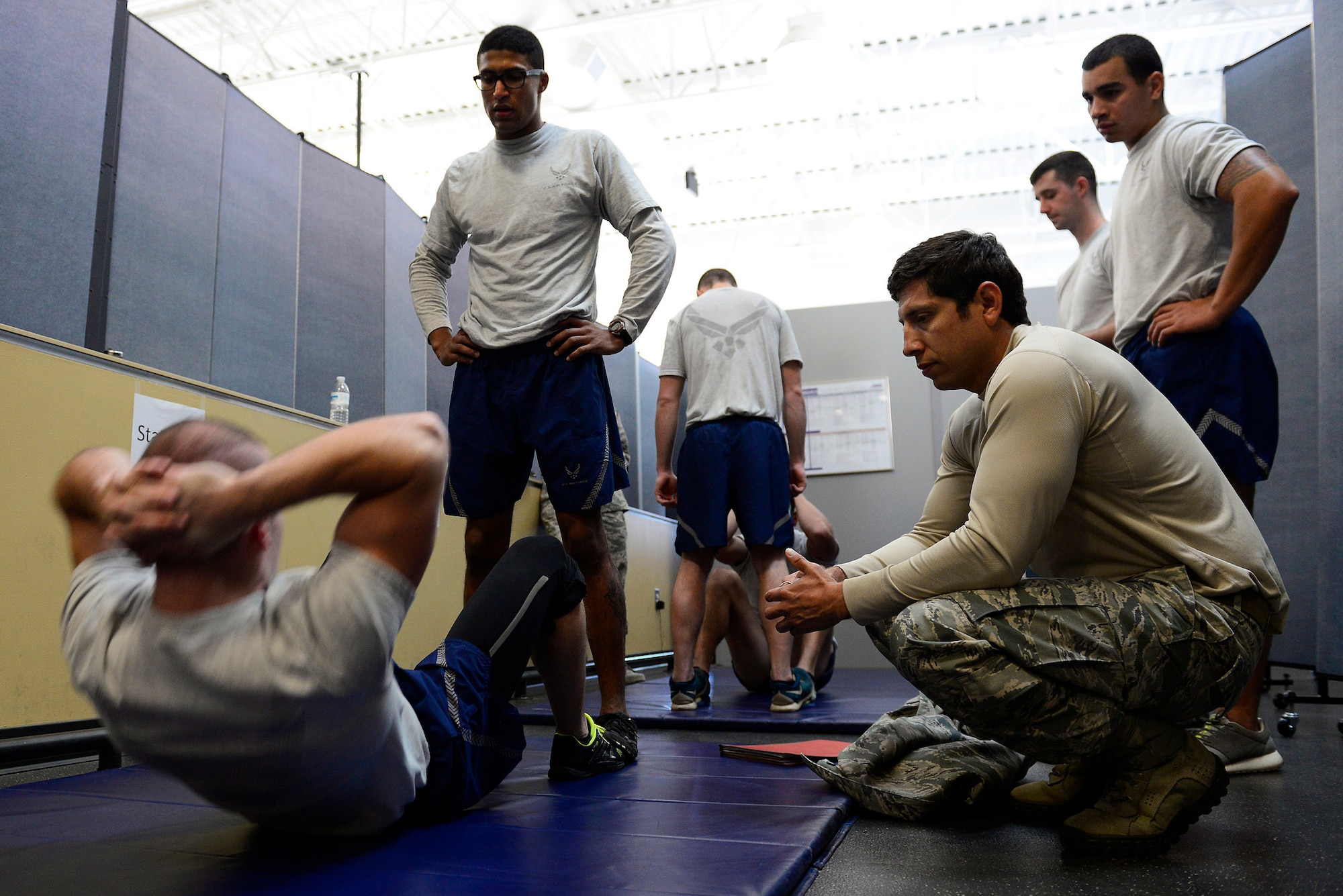 Master Sgt. Ismael Villegas, section chief of the Recruitment, Assesment and Selection program, administers a physical ability and stamina test at Shaw Air Force Base, S.C., Dec. 10, 2014. In a two-minute time frame, the Airmen had to perform a specified amount of sit-ups, push-ups, and pull-ups required by the specific Special Tactics career field they wished to enter. (U.S. Air Force photo by Airman 1st Class Diana M. Cossaboom/Released)