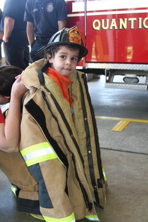 A military child tries on a fireman's coat during a tour of Fire Station 531 aboard Marine Corps Base Quantico.