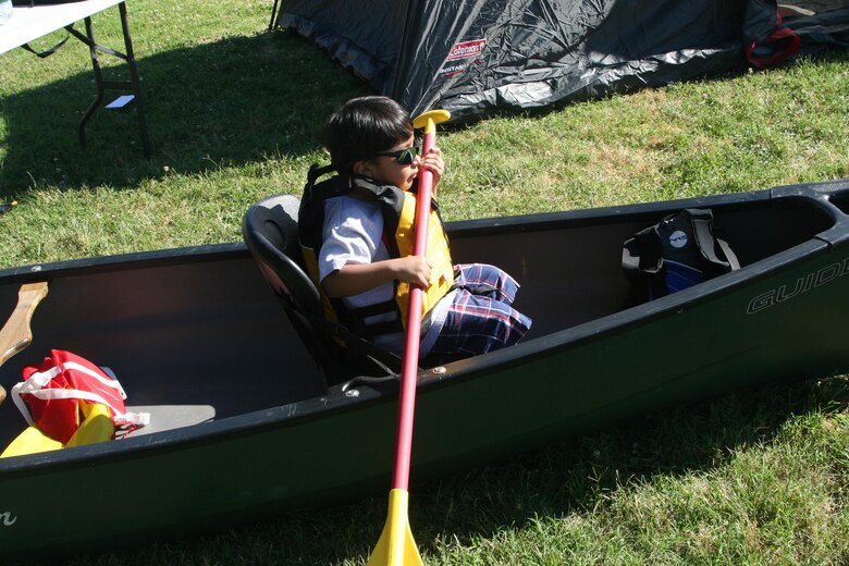 A military child gives kayaking a try. Quantico Outdoor Adventures provided a kayak and a tent to the Quantico EFMP event “Camping at Barnett Field,” which gave children a chance to try out camping.