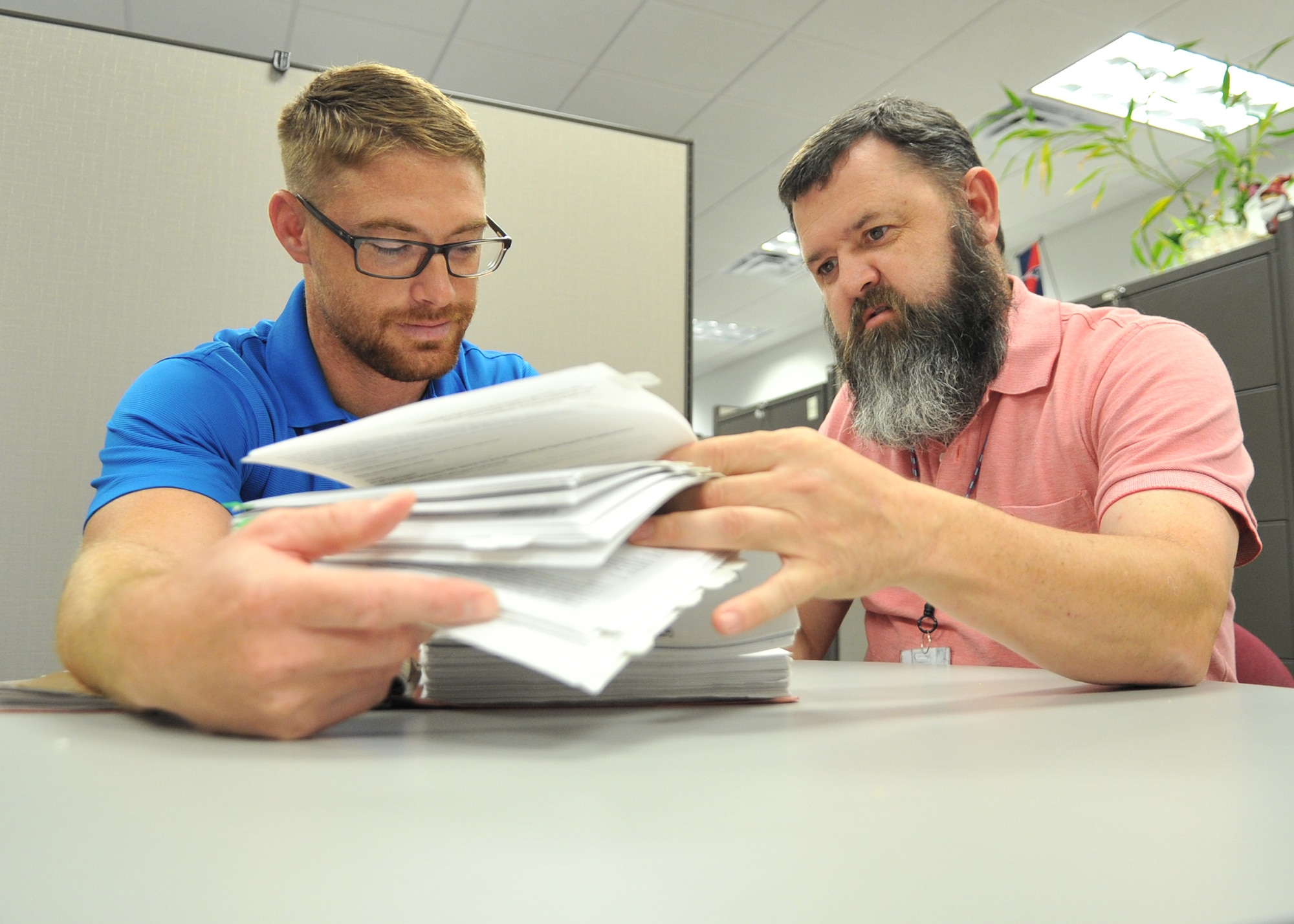 Alex Larsen and Randy Jones, 772nd Enterprise Sourcing Squadron contracting officers, review vital contracting support services documents at the Air Force Civil Engineer Center, June 23, 2016. These documents outline requirements and guidelines to select contract services best suited for Air Force mission objectives. (U.S. Air Force photo by Senior Airman Ty-Rico Lea/Released)
