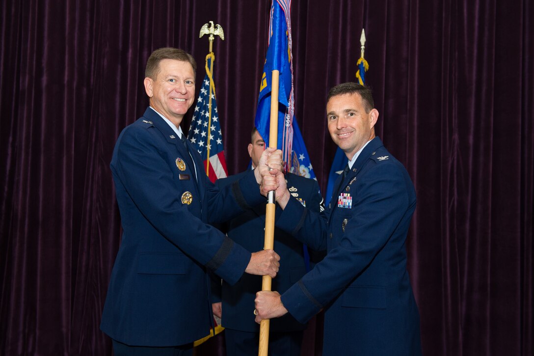 Brig. Gen. Wayne Monteith, 45th Space Wing commander, presents Col. Burton Catledge, 45th Operations Group commander, with a guidon during a change of command ceremony June 30, 2016, at Patrick Air Force Base, Fla. Changes of command are a military tradition representing the transfer of responsibilities from the presiding official to the upcoming official. (U.S. Air Force photo/Benjamin Thacker/Released)