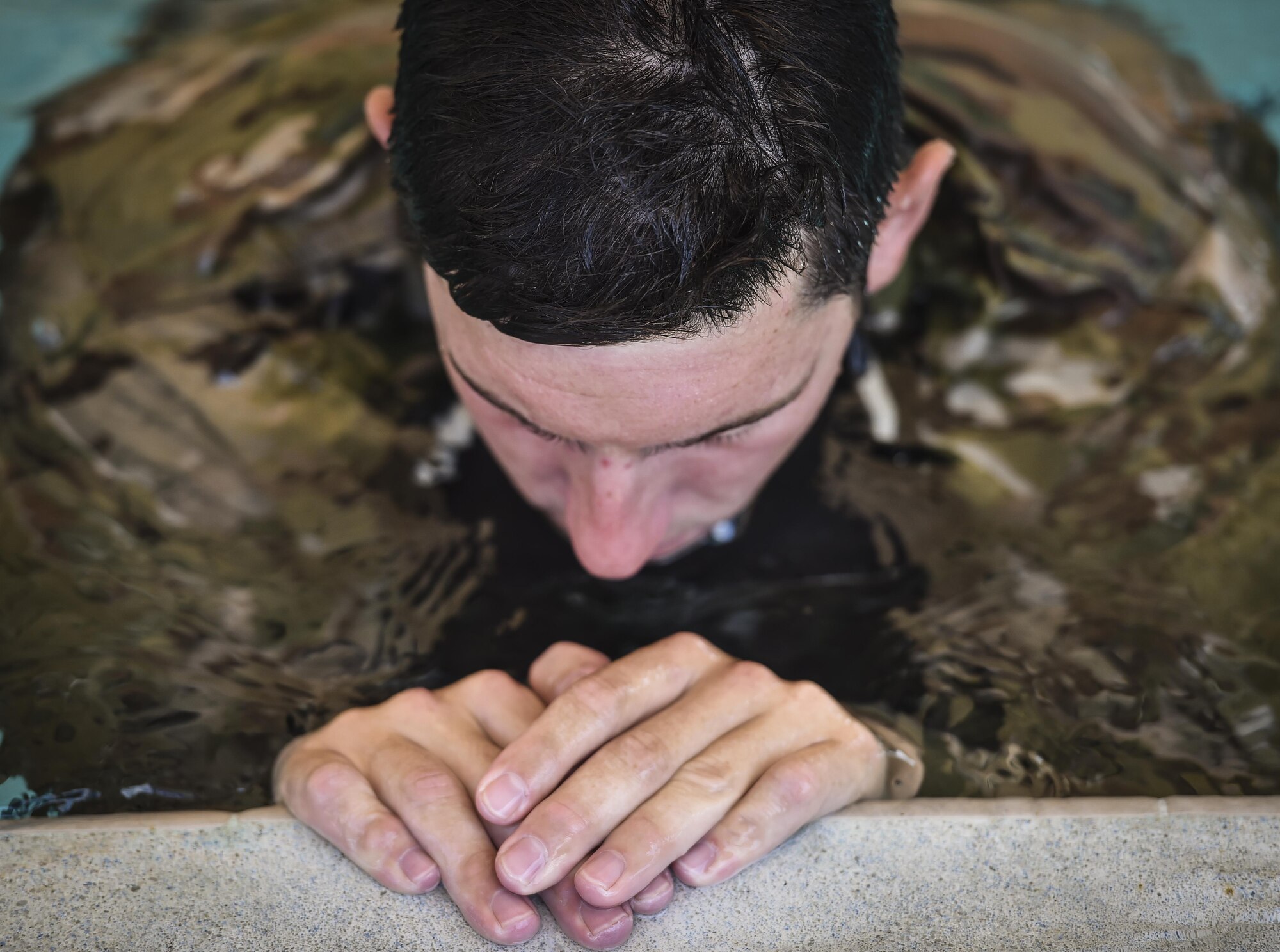 A Special Tactics Training Squadron student rests during a pre-scuba class at Hurlburt Field, Fla., June 29, 2016. The training familiarizes trainees with the basics of water operations. The trainees perform tasks such as tying knots underwater, learning how to stay afloat without their arms and hands, and how to use snorkeling gear. Special Tactics students later apply this knowledge to combat dive training. This training also reproduces physiological effects similar those experienced on the battlefield, and thus builds the necessary mental resiliency for ground special operations force. (U.S. Air Force photo by Senior Airman Ryan Conroy) 